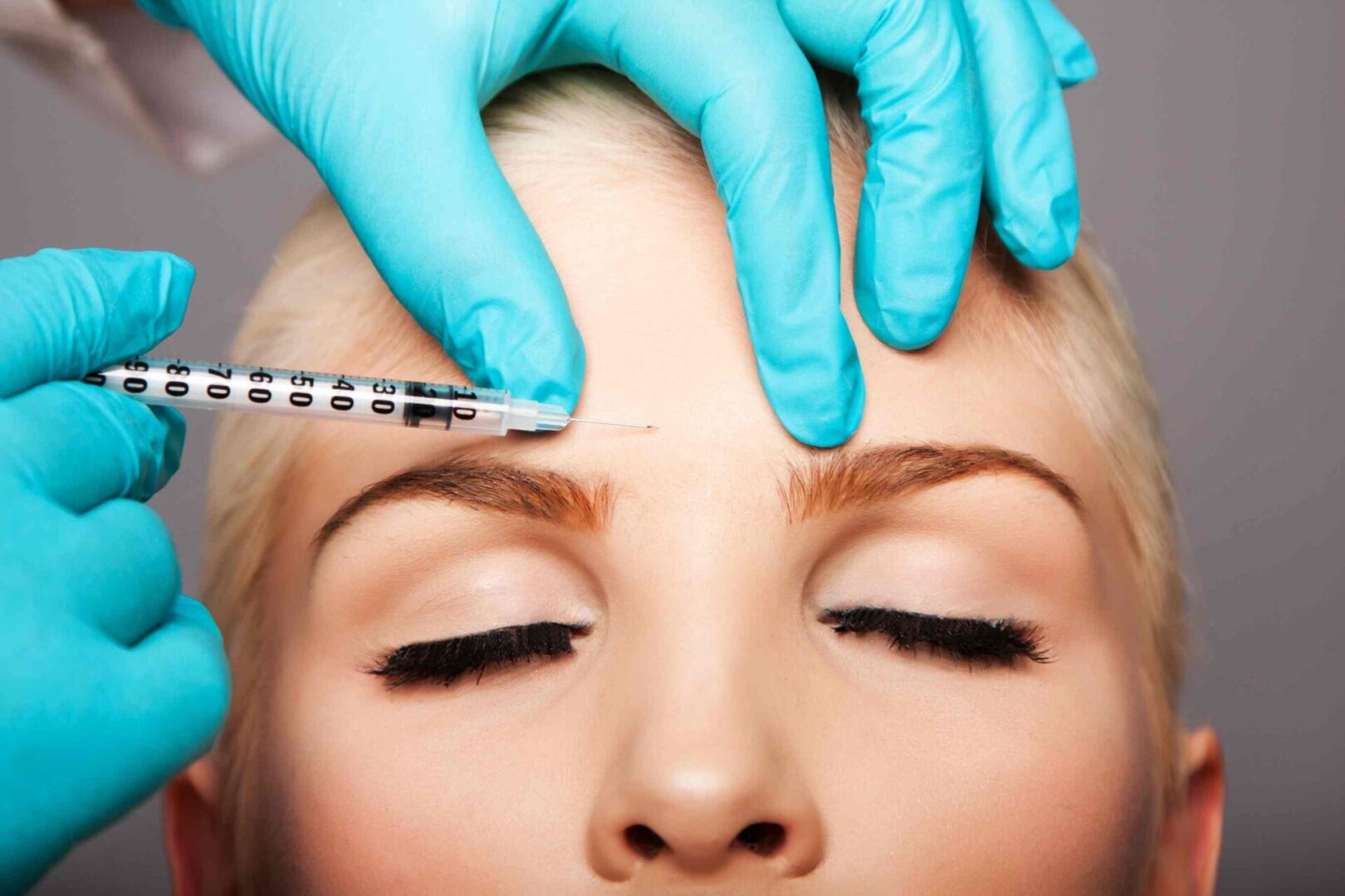 A woman getting an injection in her forehead.