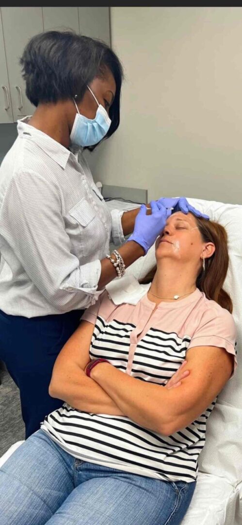 A woman getting her face waxed by a doctor.